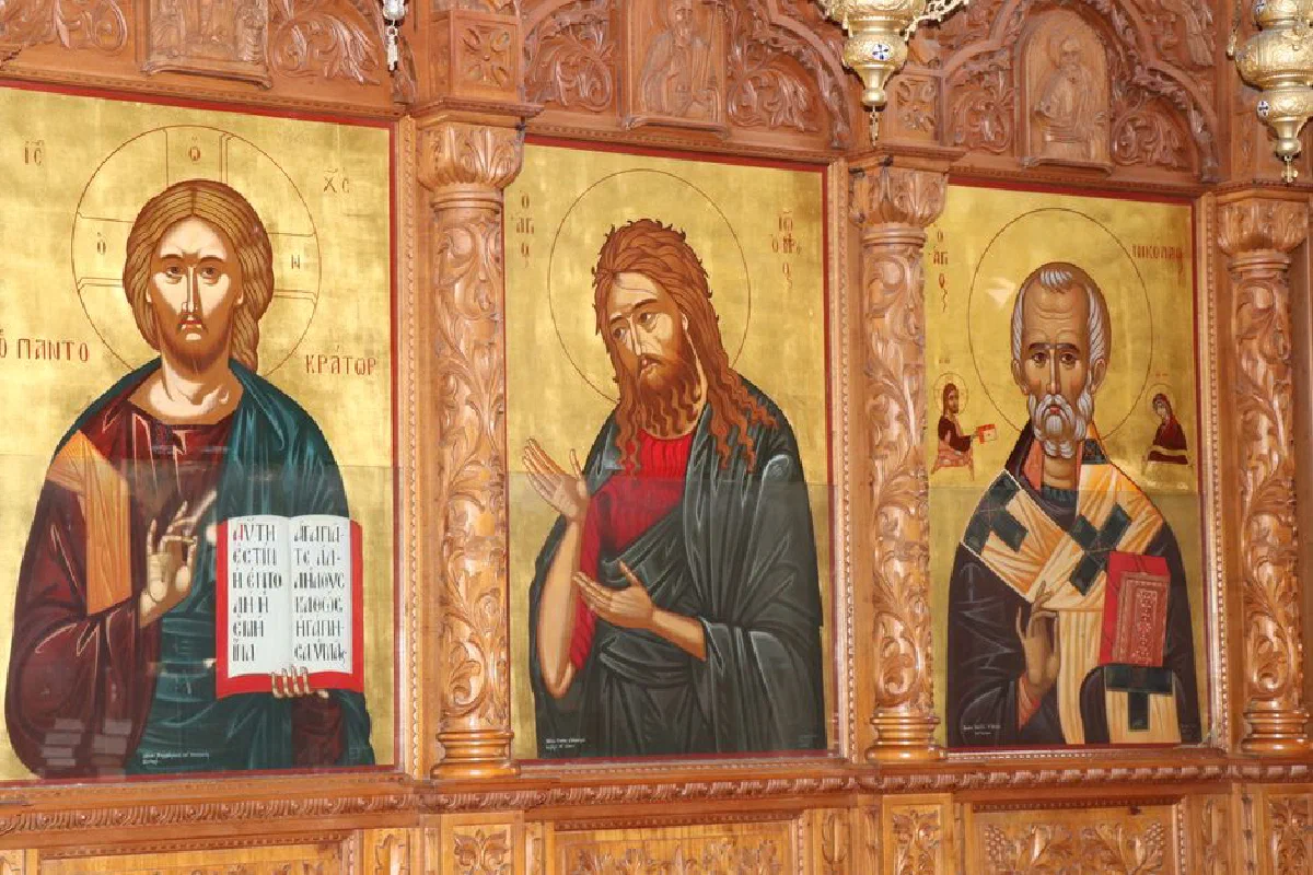 Detailed traditional religious icon paintings on a wooden church wall.