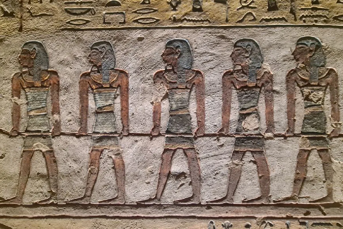 Stone relief of ancient Egyptian figures and hieroglyphs from Luxor, Egypt, showcasing historical artistry.