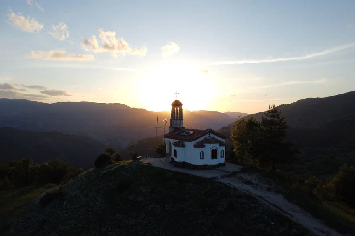A serene view of a chapel on a hill at sunrise in Borovo, Plovdiv Province, Bulgaria.