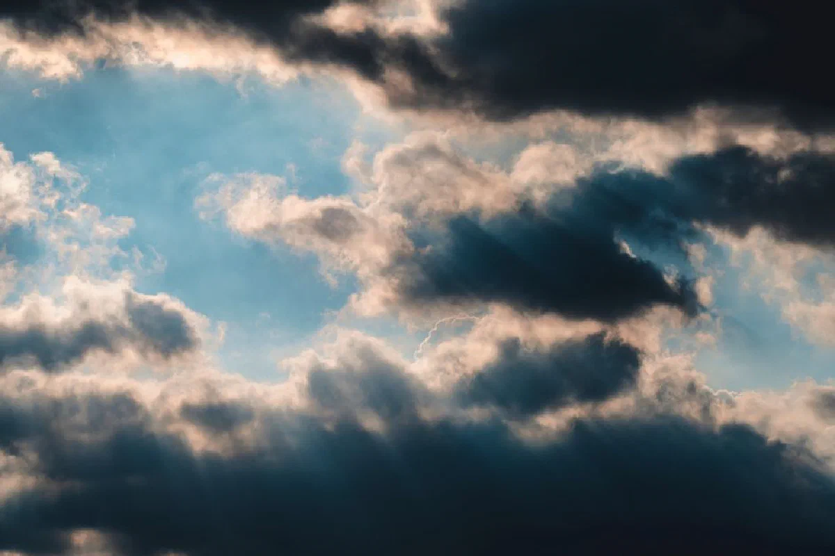 Majestic clouds with sunrays peeking through, creating a dramatic sky scene.