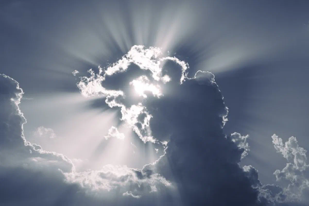 Sunlight streaming through dramatic clouds creating a heavenly effect in the sky.
